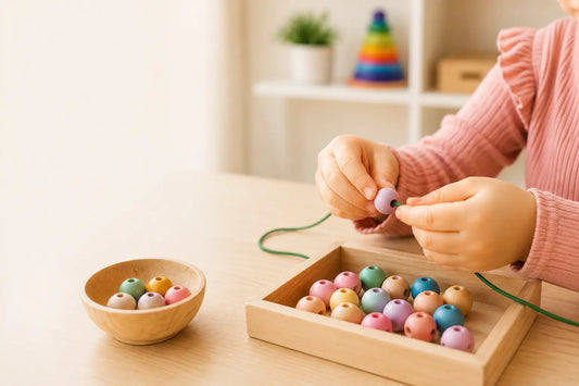 Young child practising fine motor skills by threading colourful wooden beads during Montessori-inspired hands-on learning and play.