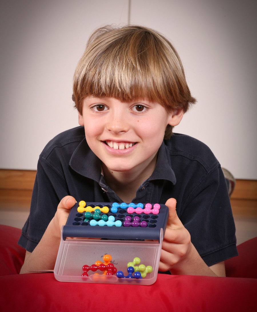 Boy solving 3D brain teaser puzzle at a desk