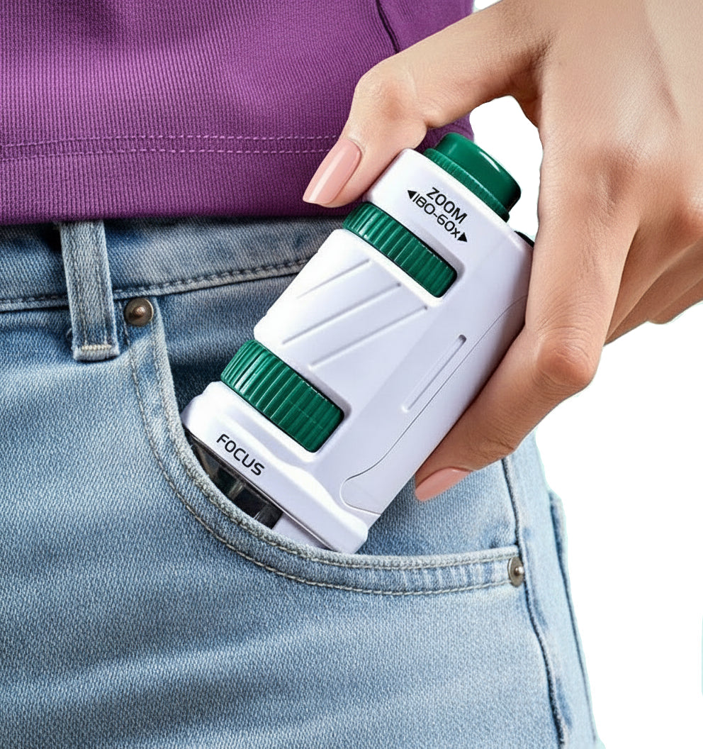 Hand holding a small white and green telescope 