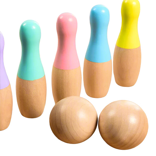 Set of wooden bowling pins with colourful tops on a wooden surface