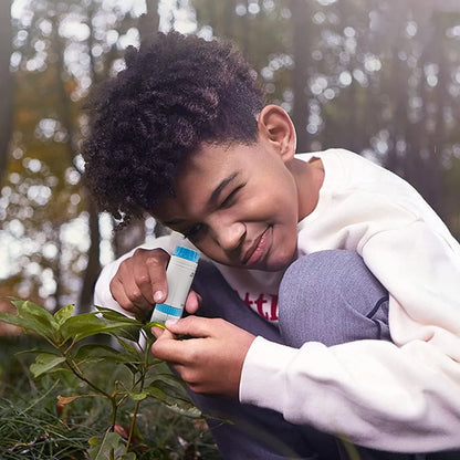 Child using the Pocket Discovery Microscope outdoors